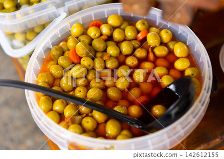 Green pitted olives with carrots and garlic in bucket 142612155