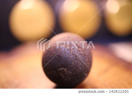 Dark Chocolate Truffle with Blurred Golden Spheres Dark Chocolate Truffle with Blurred Golden Spheres 142612201