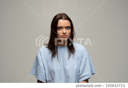Young woman showing worry and concern, experiencing fear or anxiety, sitting in a studio, full body looking at camera Young woman showing worry and concern, experiencing fear or anxiety, sitting in a studio, full body looking at camera 142612713