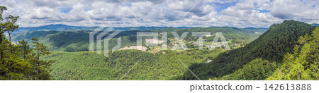 Panoramic view showing San Cristobal de las Casas and surrounding mountains in Chiapas Mexico with colonial town highland landscape cloudy sky rooftops streets and wide travel panorama. Panoramic view showing San Cristobal de las Casas and surrounding mountains in Chiapas Mexico with colonial town highland landscape cloudy sky rooftops streets and wide travel panorama. 142613888