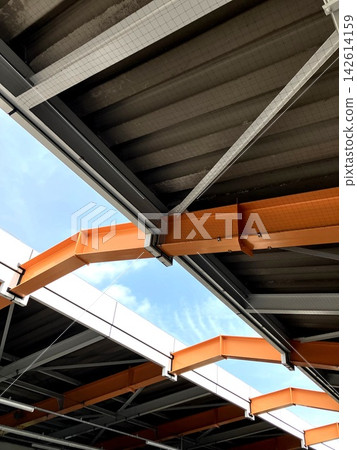 Orange steel beams and roof: A view of the building structure from above. Orange steel beams and roof: A view of the building structure from above. 142614159