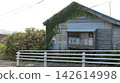 Dilapidated vacant house and guardrails covered in weeds and vines; aging wooden house; vacant house problem; social problem 142614998