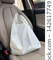 Shopping bags placed on the passenger seat of the car 142617749