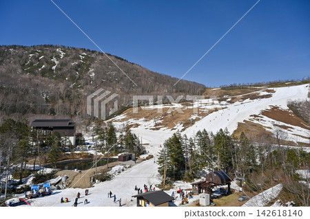 Spring skiing in Hakuba, Nagano Prefecture: Scenes of ski resorts in the process of melting snow and remaining snow on the slopes under a blue sky [Nagano/Hakuba mountain scenery photography] 142618140