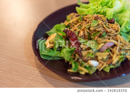 Spicy Thai bamboo shoot salad mixed fresh herbs dried chili onion seasoning served crisp green lettuce dark plate copy space Spicy Thai bamboo shoot salad mixed fresh herbs dried chili onion seasoning served crisp green lettuce dark plate copy space 142618358