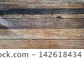 Top-down view of rustic, weathered wooden planks arranged horizontally with deeply grooved grain patterns, tactile wood fibers, split edges, and weathered character lines 142618434