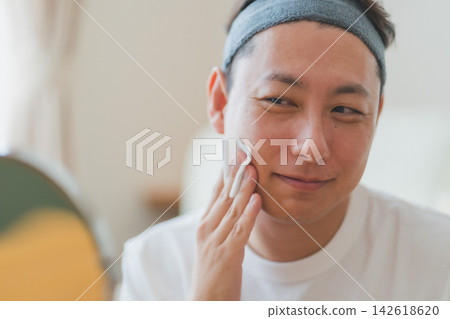 Men's skincare for men in their 40s: Applying lotion slowly with cotton pads to allow it to penetrate deeply. Men's skincare for men in their 40s: Applying lotion slowly with cotton pads to allow it to penetrate deeply. 142618620