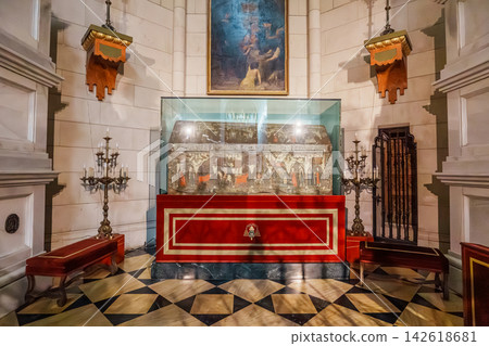 Ornate silver reliquary tomb displayed in a marble chapel niche in Almudena Cathedral Ornate silver reliquary tomb displayed in a marble chapel niche in Almudena Cathedral 142618681