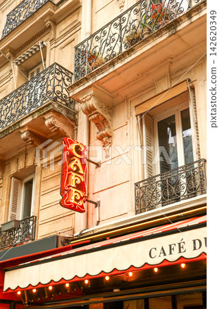 Paris cafe neon sign creating a vibrant focal point on a historic french building with balconies and shuttered windows Paris cafe neon sign creating a vibrant focal point on a historic french building with balconies and shuttered windows 142620349