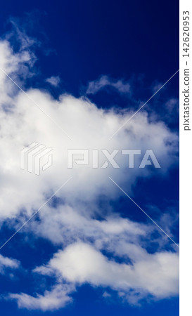 a large white cloud set against a deepening saturated blue sky a large white cloud set against a deepening saturated blue sky 142620953