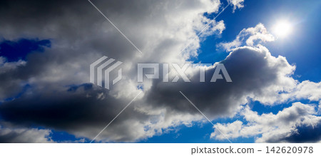 bright sun disc behind dark cumulus clouds bright sun disc behind dark cumulus clouds 142620978