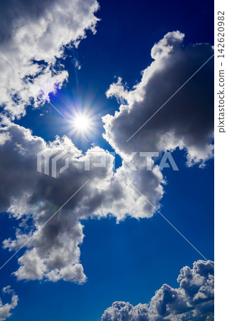 sunstar bursting through clouds in the middle of a clear blue sky sunstar bursting through clouds in the middle of a clear blue sky 142620982