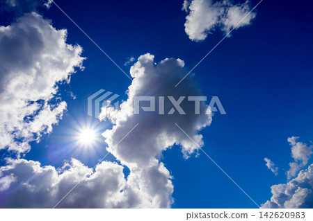 bright sun shining on the left of a giant cumulus cloud in the blue sky bright sun shining on the left of a giant cumulus cloud in the blue sky 142620983