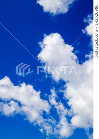 soft white clouds scattered across a high vibrant blue sky 142620986