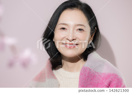 一張明亮的冬日照片,一位五十多歲的女性身披披肩,面帶自然微笑,展現出迷人的美麗。 一張明亮的冬日照片,一位五十多歲的女性身披披肩,面帶自然微笑,展現出迷人的美麗。 142621300