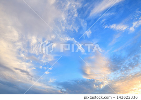 White clouds spread across a bright blue sky. White clouds spread across a bright blue sky. 142622336