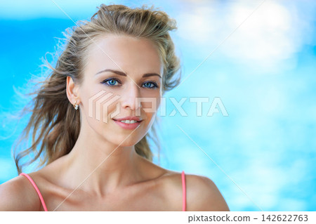 Woman in Coral Pink Top by Blue Background Woman in Coral Pink Top by Blue Background 142622763