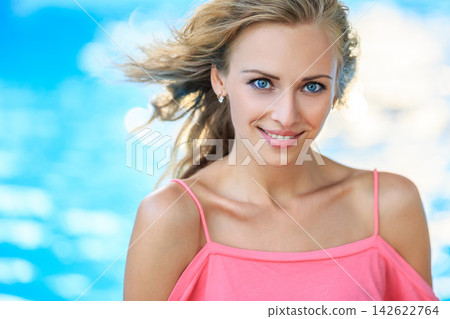 Woman in Coral Pink Top by Blue Background Woman in Coral Pink Top by Blue Background 142622764