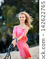 Woman in Pink Dress Outdoors 142622765