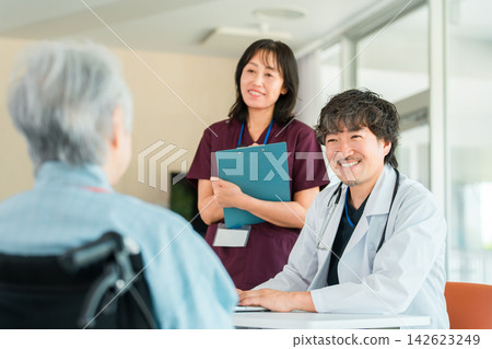 醫生和護理人員面帶微笑地幫助坐在輪椅上的老人;提供老年護理和福利服務方面的諮詢。 醫生和護理人員面帶微笑地幫助坐在輪椅上的老人;提供老年護理和福利服務方面的諮詢。 142623249