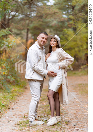 A loving couple poses together in a beautiful forest setting, celebrating their upcoming parenthood A loving couple poses together in a beautiful forest setting, celebrating their upcoming parenthood 142623440