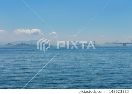 The Seto Ohashi Bridge spanning the Seto Inland Sea, the distant mountain range, and the tranquil seascape. The Seto Ohashi Bridge spanning the Seto Inland Sea, the distant mountain range, and the tranquil seascape. 142623583