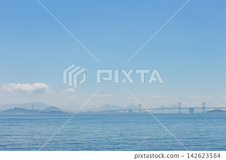 瀨戶大橋橫跨瀨戶內海,寧靜的海景,以及遠處可見的山脈和城市景觀。 瀨戶大橋橫跨瀨戶內海,寧靜的海景,以及遠處可見的山脈和城市景觀。 142623584