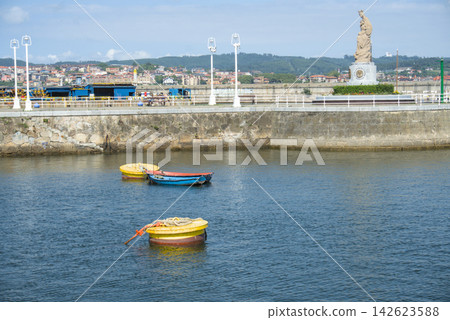 Yellow mooring buoys and small boats in Santurtzi harbour below the Virgen del Carmen Yellow mooring buoys and small boats in Santurtzi harbour below the Virgen del Carmen 142623588