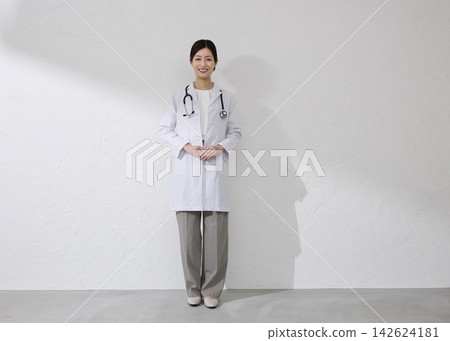 Female doctor wearing white coat Female doctor wearing white coat 142624181