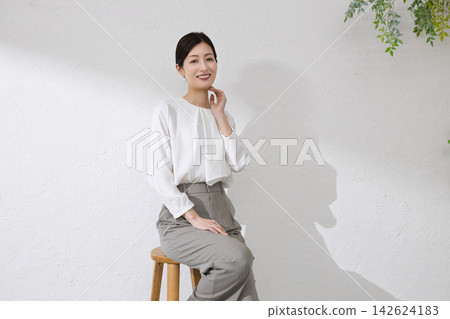 一位中年婦女用手摀著臉頰 一位中年婦女用手摀著臉頰 142624183