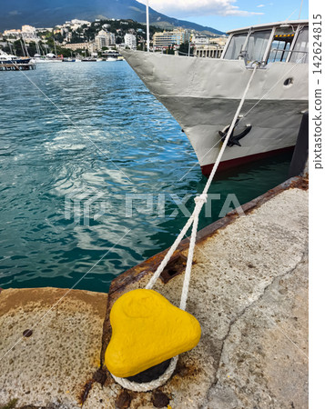 Boat moored at dock with yellow cleat in clear water Boat moored at dock with yellow cleat in clear water 142624815