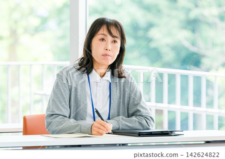 A female staff member taking notes while listening during training sessions and interviews - an image of talent development and new employee training. A female staff member taking notes while listening during training sessions and interviews - an image of talent development and new employee training. 142624822