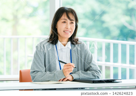 A female staff member taking notes while listening during training sessions and interviews - an image of talent development and new employee training. A female staff member taking notes while listening during training sessions and interviews - an image of talent development and new employee training. 142624823