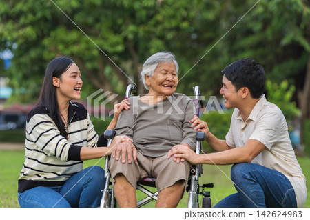 senior woman in wheelchair surrounded by loving family members in nature senior woman in wheelchair surrounded by loving family members in nature 142624983