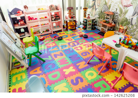Playroom for preschool children, colored toys scattered around room Montessori Playroom for preschool children, colored toys scattered around room Montessori 142625208