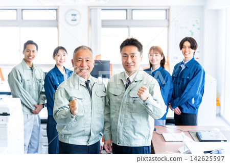 辦公室裡,一男一女身穿工作服,面帶微笑,擺出勝利的姿勢。 辦公室裡,一男一女身穿工作服,面帶微笑,擺出勝利的姿勢。 142625597