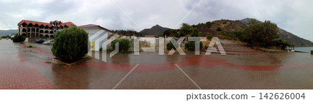 panorama of embankment and mountain town under cloudy sky near sea panorama of embankment and mountain town under cloudy sky near sea 142626004