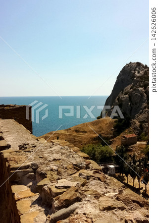 stone fortress wall near sea against backdrop of rocky hill stone fortress wall near sea against backdrop of rocky hill 142626006