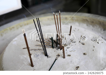 Incense sticks standing in an incense burner Incense sticks standing in an incense burner 142626075