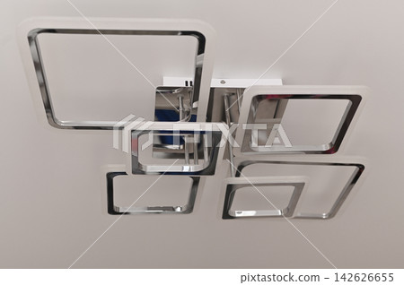 Modern chandelier illuminates minimalist room. 142626655