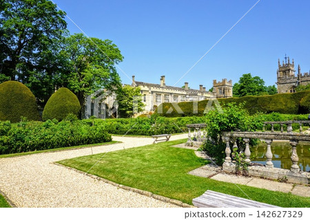 英國歷史悠久的建築和花園,周圍環繞著藍天和綠樹。 英國歷史悠久的建築和花園,周圍環繞著藍天和綠樹。 142627329