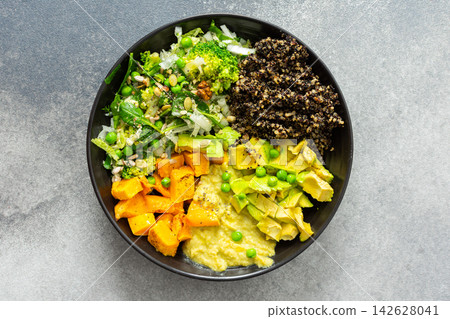 A bowl filled with quinoa, roasted pumpkin, hummus, and a salad of fresh avocado is ready to eat. This meal is gluten free and offers a healthy start to the day A bowl filled with quinoa, roasted pumpkin, hummus, and a salad of fresh avocado is ready to eat. This meal is gluten free and offers a healthy start to the day 142628041