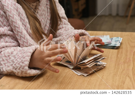 Small child hands counting money bills. Small child hands counting money bills. 142628535