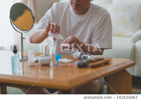 中年男士護膚:用潤膚露浸濕化妝棉。 中年男士護膚:用潤膚露浸濕化妝棉。 142628862