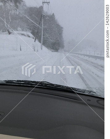 冬季道路積雪覆蓋,能見度因大雪而降低。 冬季道路積雪覆蓋,能見度因大雪而降低。 142629003