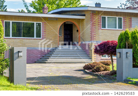 Mid-Century Modern Suburban House with Brick Facade and Arched Entrance Mid-Century Modern Suburban House with Brick Facade and Arched Entrance 142629583