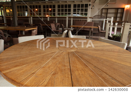 Wooden table set for dining at a restaurant patio during afternoon Wooden table set for dining at a restaurant patio during afternoon 142630008