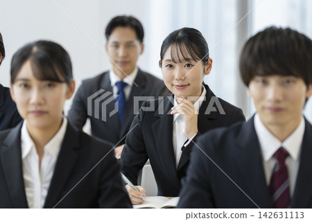 身著西裝的年輕男女正在參加研討會。 身著西裝的年輕男女正在參加研討會。 142631113