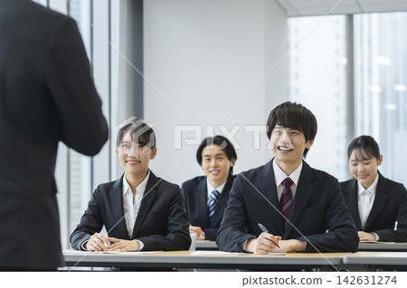 身著西裝的年輕男女正在參加研討會。 身著西裝的年輕男女正在參加研討會。 142631274
