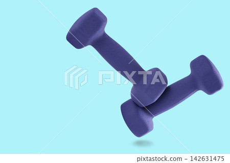 Pair of purple neoprene dumbbells levitating on light blue background with copy space Pair of purple neoprene dumbbells levitating on light blue background with copy space 142631475